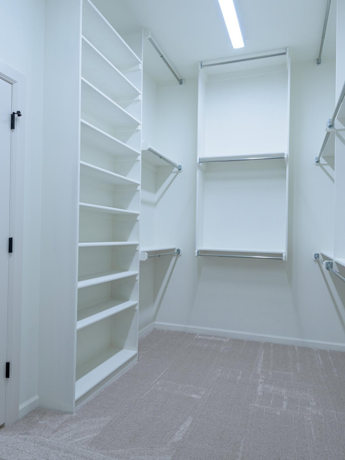 A walk in closet with shelves and a door