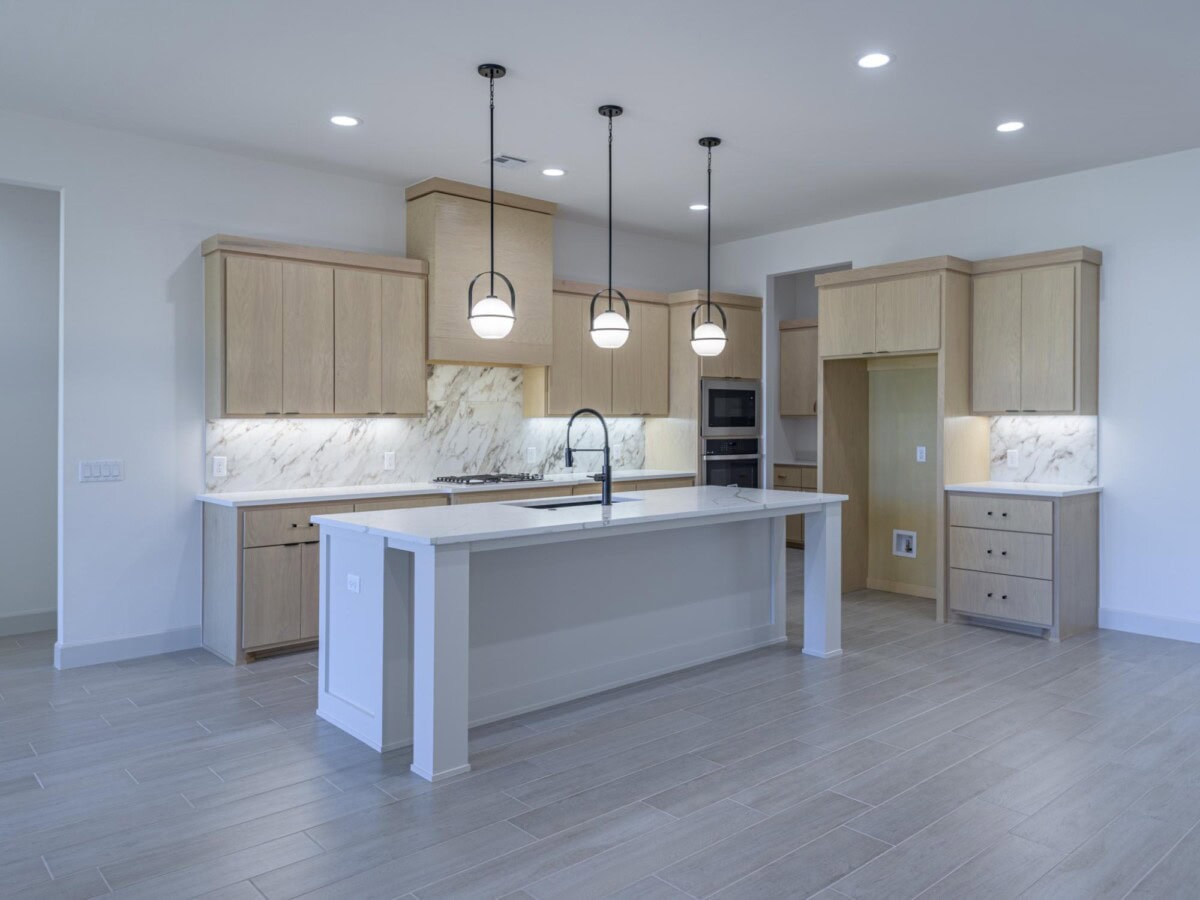 A clean kitchen with white cabinets and light wood floors