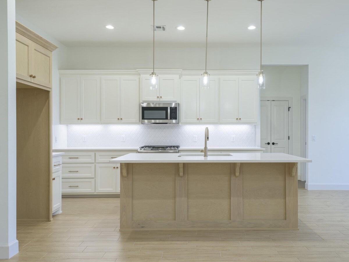 A large kitchen with white cabinets and a center island
