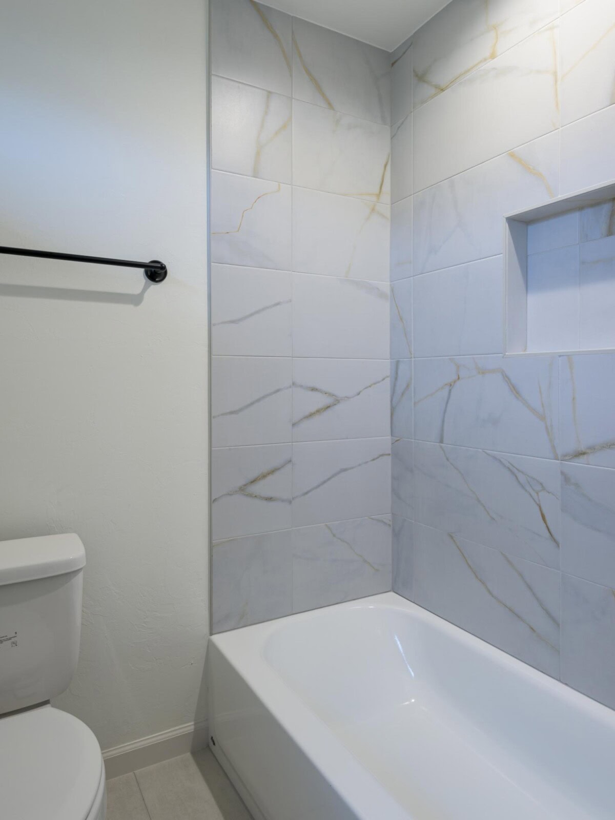A bathroom with a toilet, bathtub and a sink
