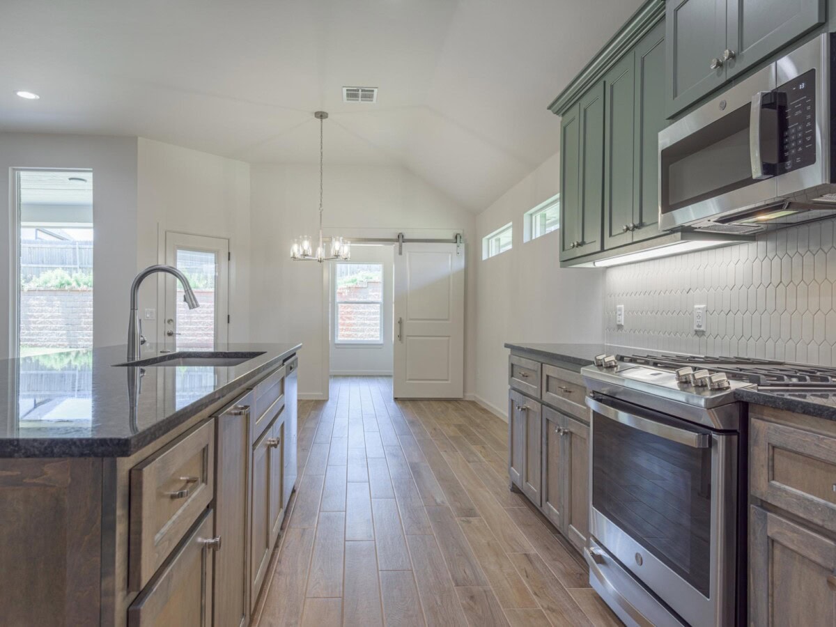 A kitchen with stainless steel appliances and wood cabinets