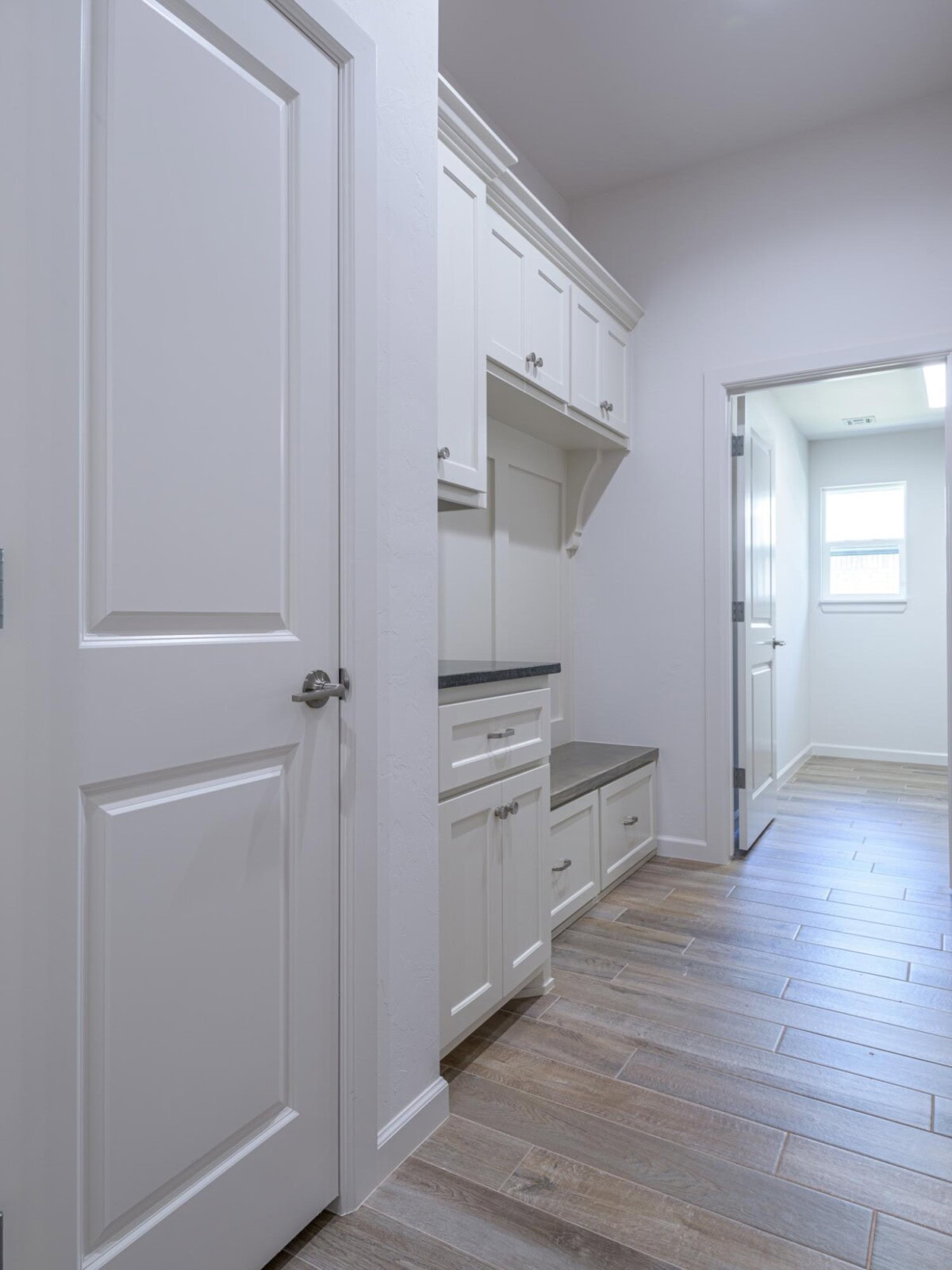 A white kitchen with white cabinets and white tile floor