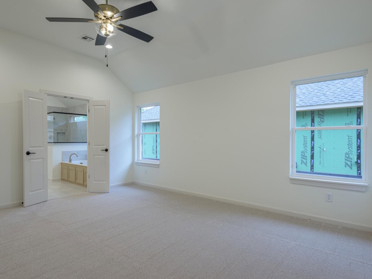 A room with a ceiling fan and two windows