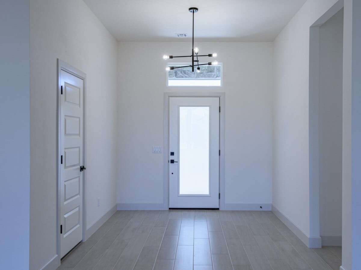 A hallway with white walls and a light fixture