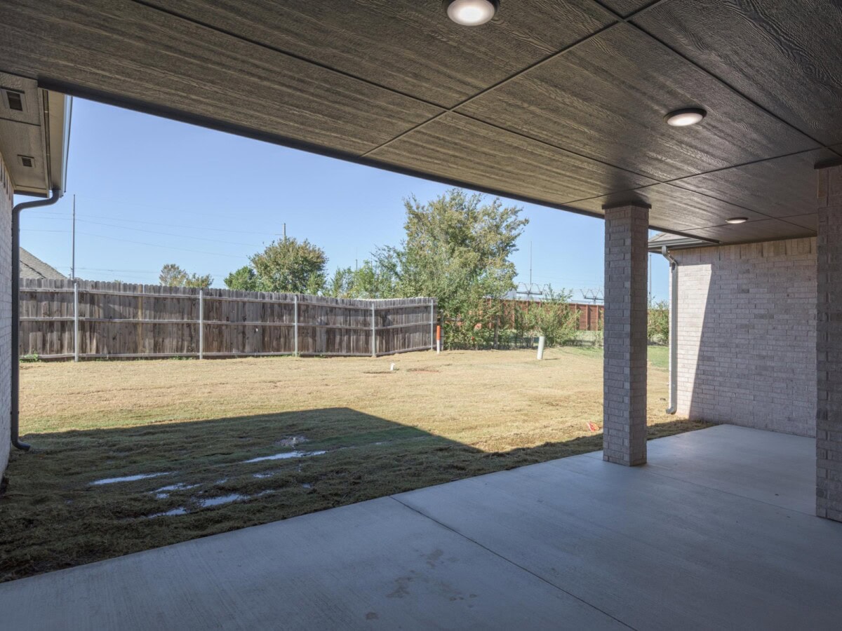 A backyard with a covered patio and a grassy area