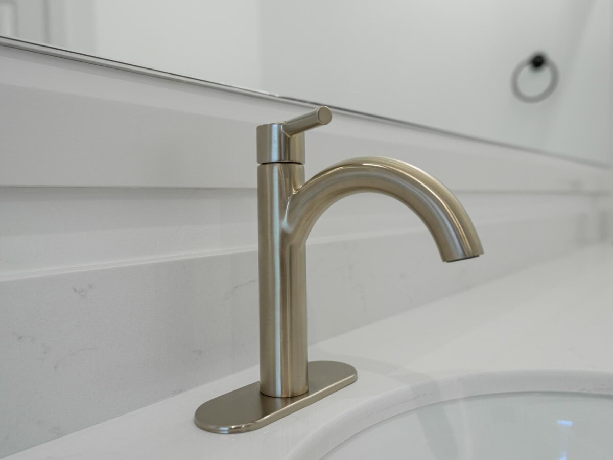 A bathroom sink with a faucet and a mirror
