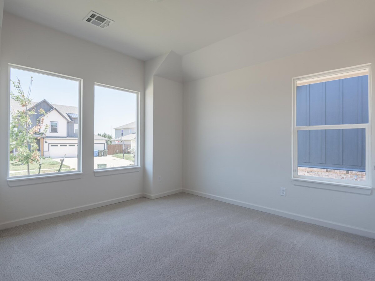 Empty room with two windows and carpeting