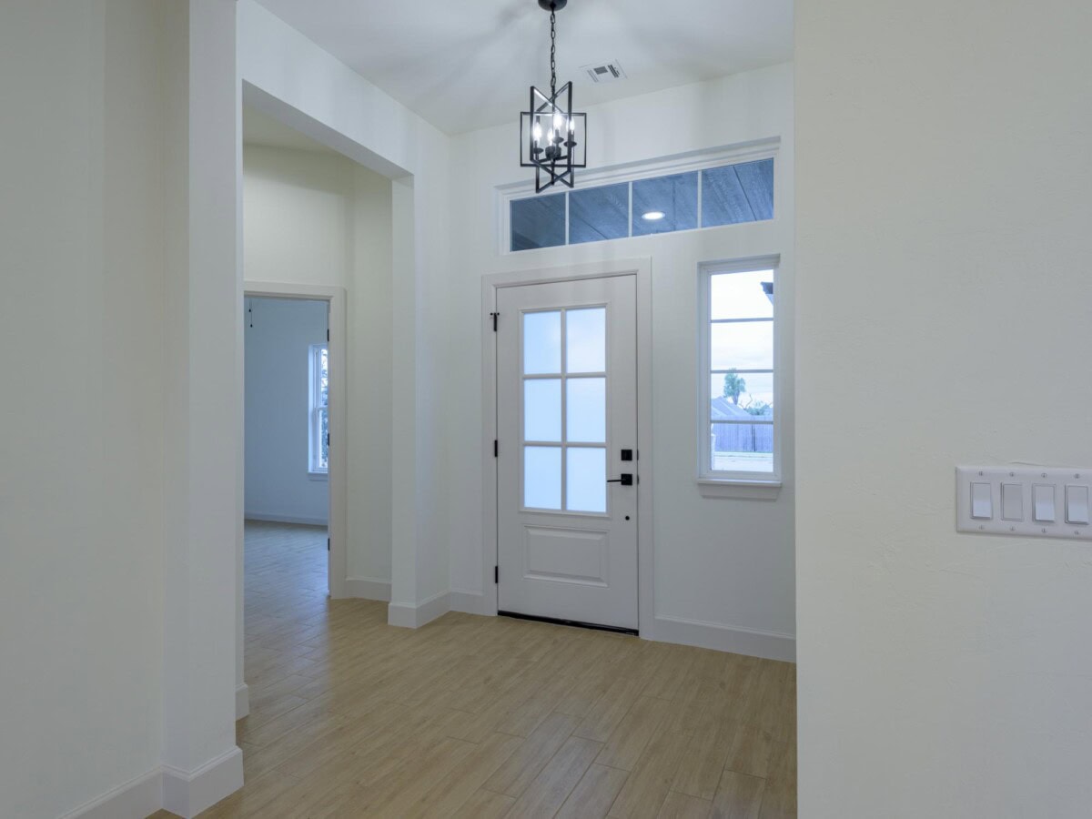 A hallway with a door and light fixture