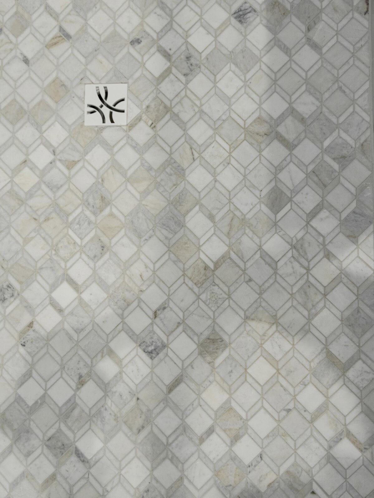 A bathroom with a white tile floor and a shower