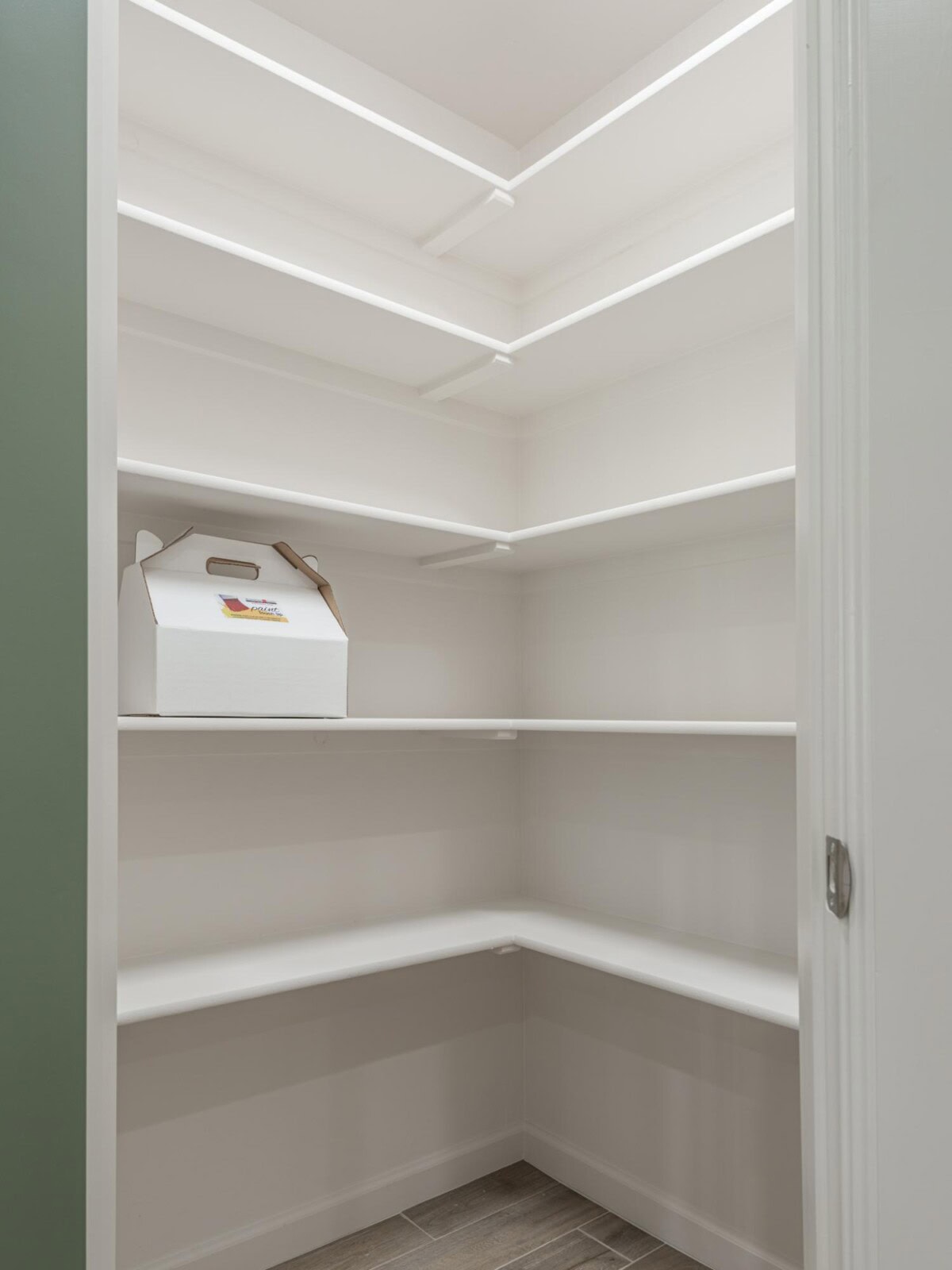 A white pantry with shelves and a box
