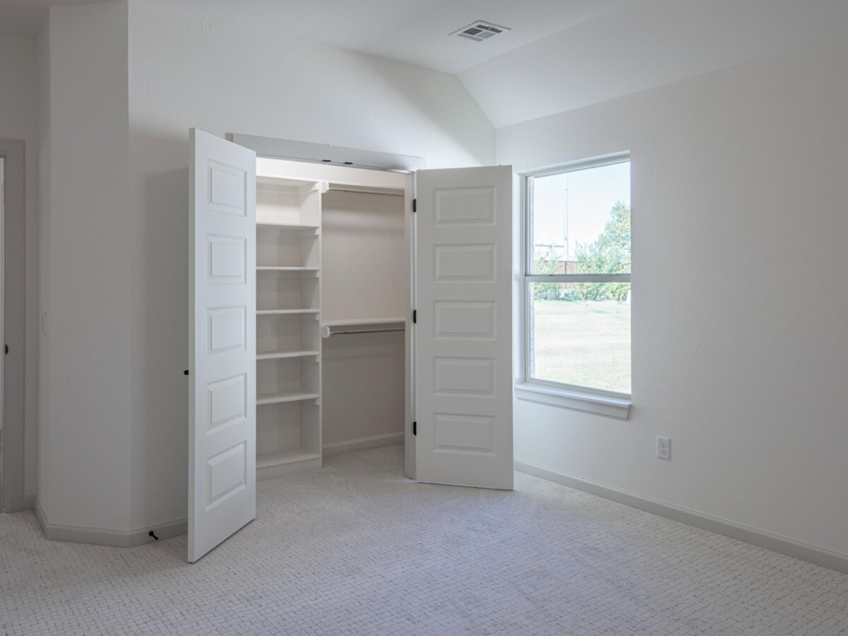 A white room with a closet and open door