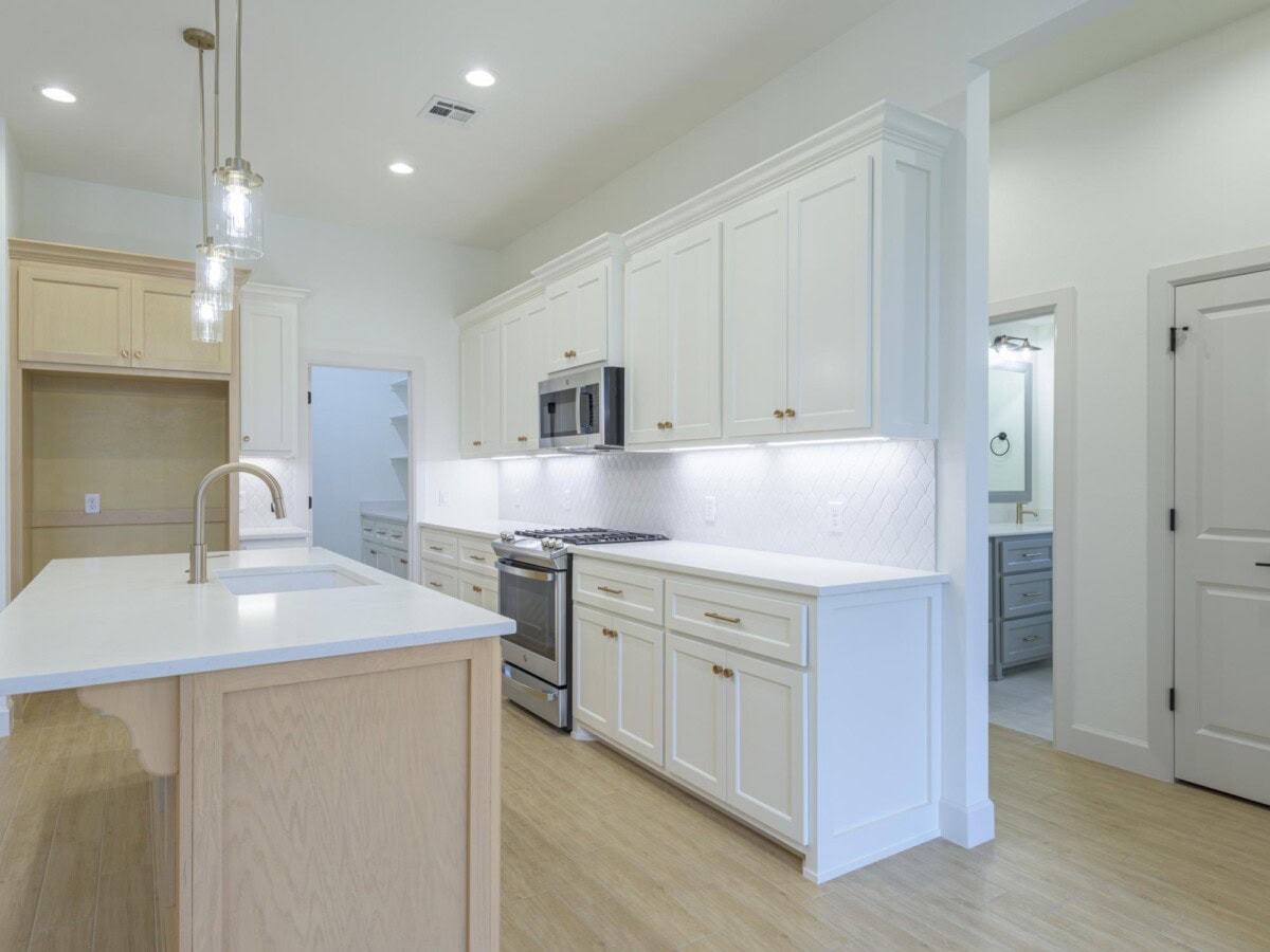 A kitchen with white cabinets and a white counter top