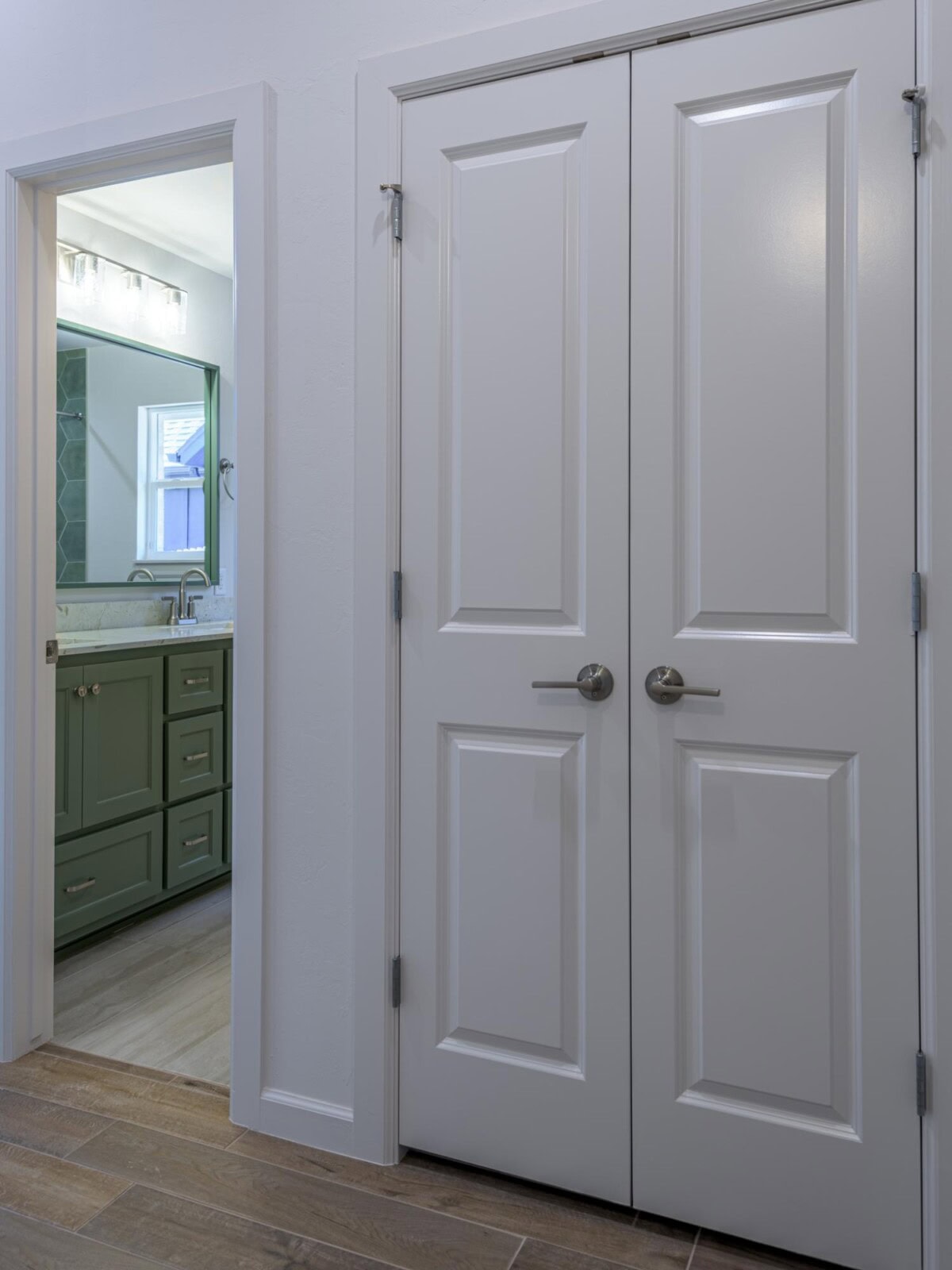 A white door with two doors and a mirror
