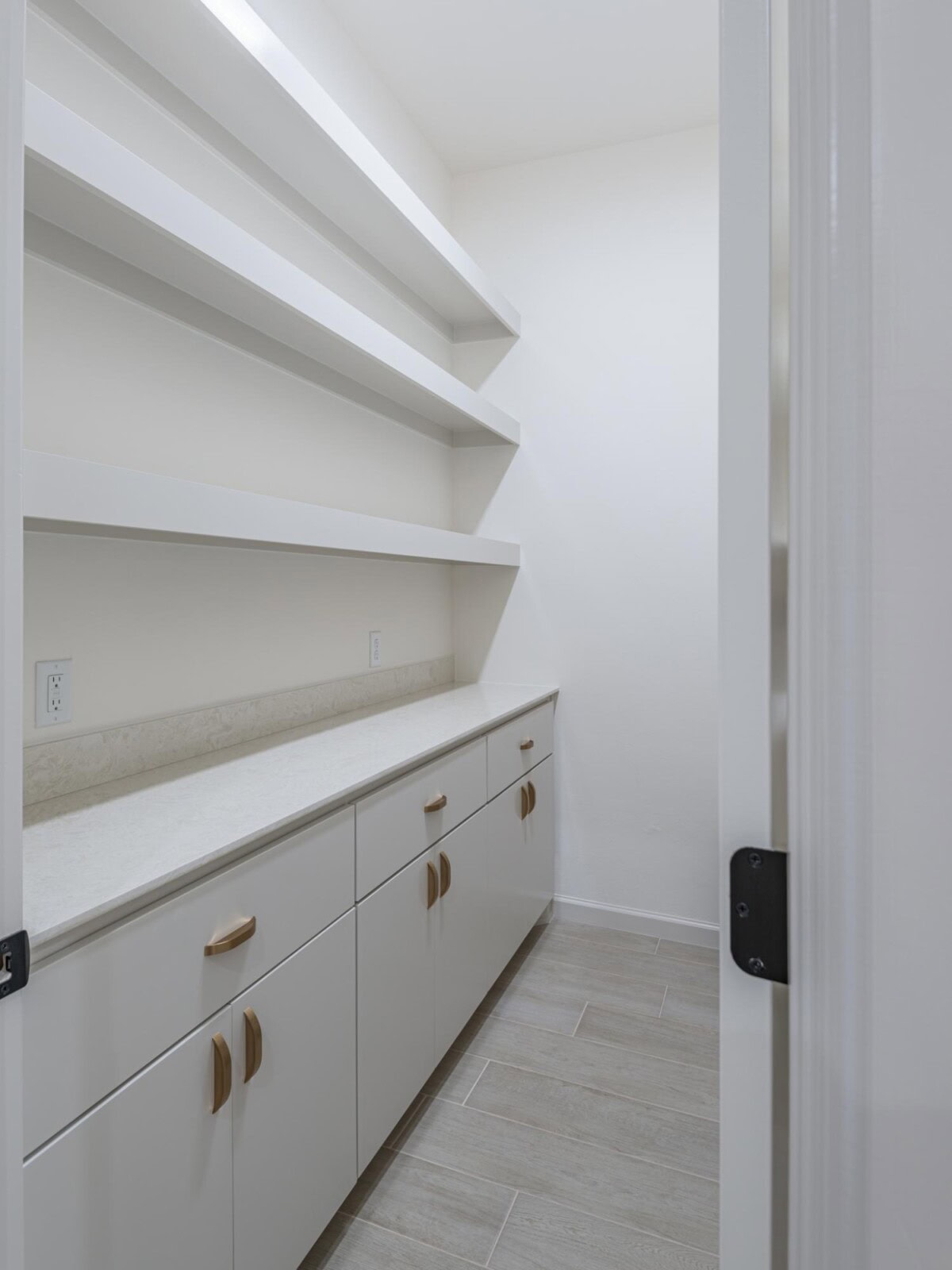 A white pantry with shelves and cabinets