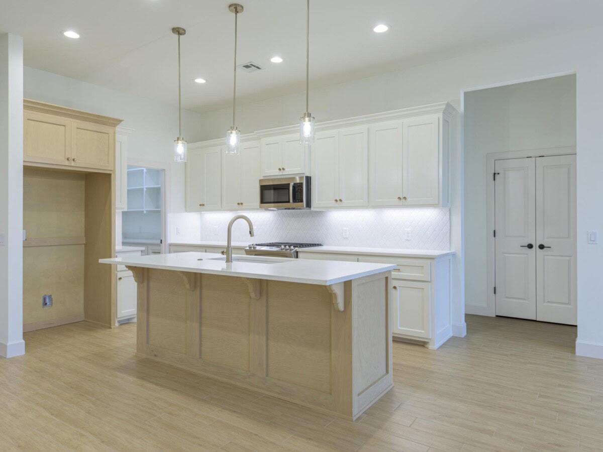 A kitchen with a center island and white cabinets