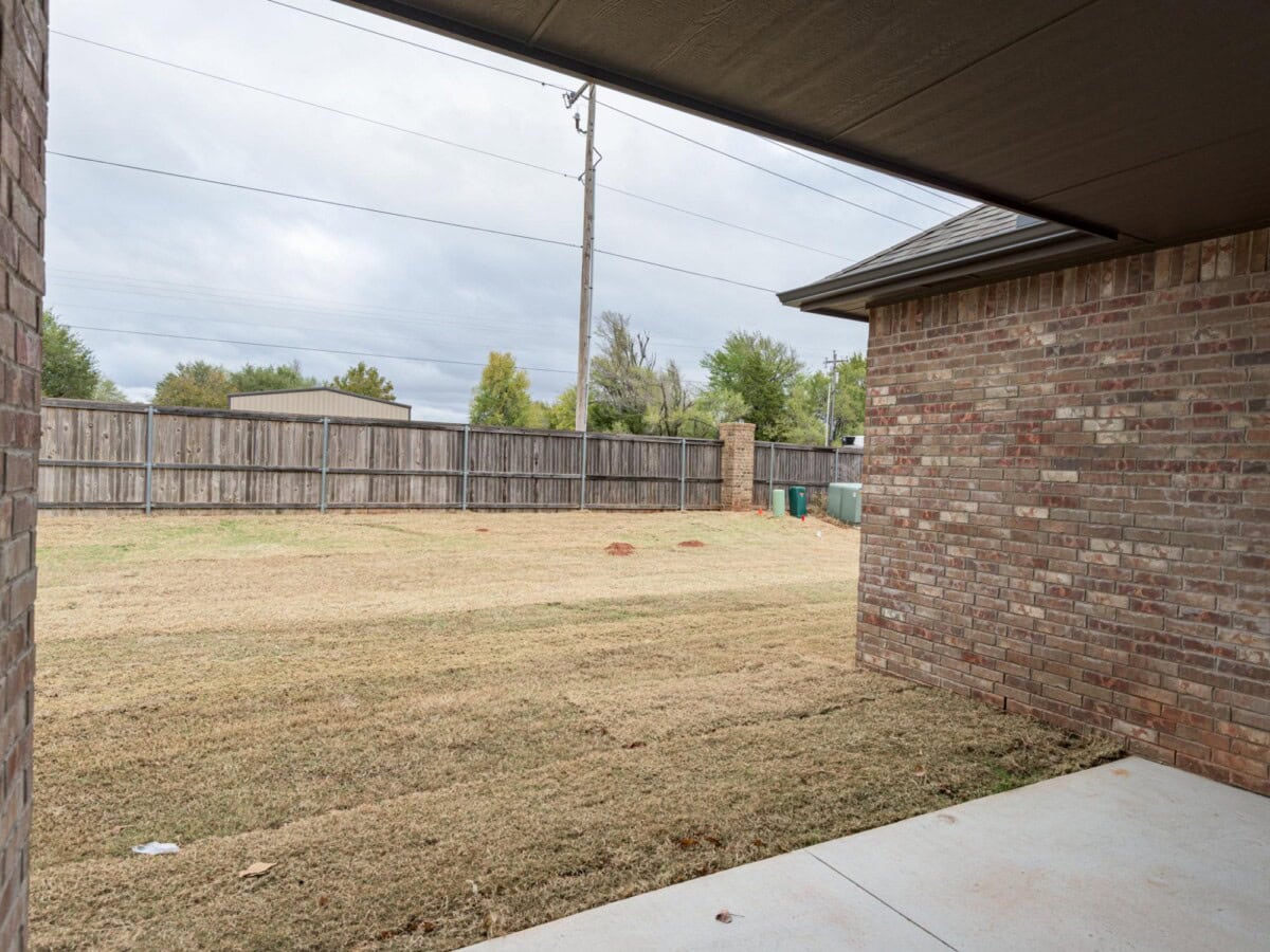 A brick wall and a fence in a backyard
