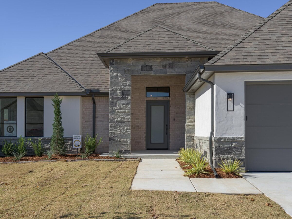 A home with a gray garage door and stone trim