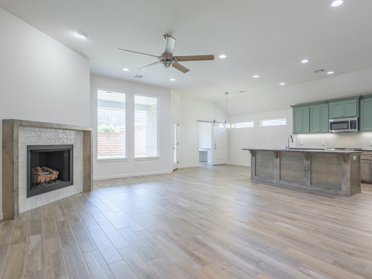 A large open kitchen with a fireplace and hardwood floors