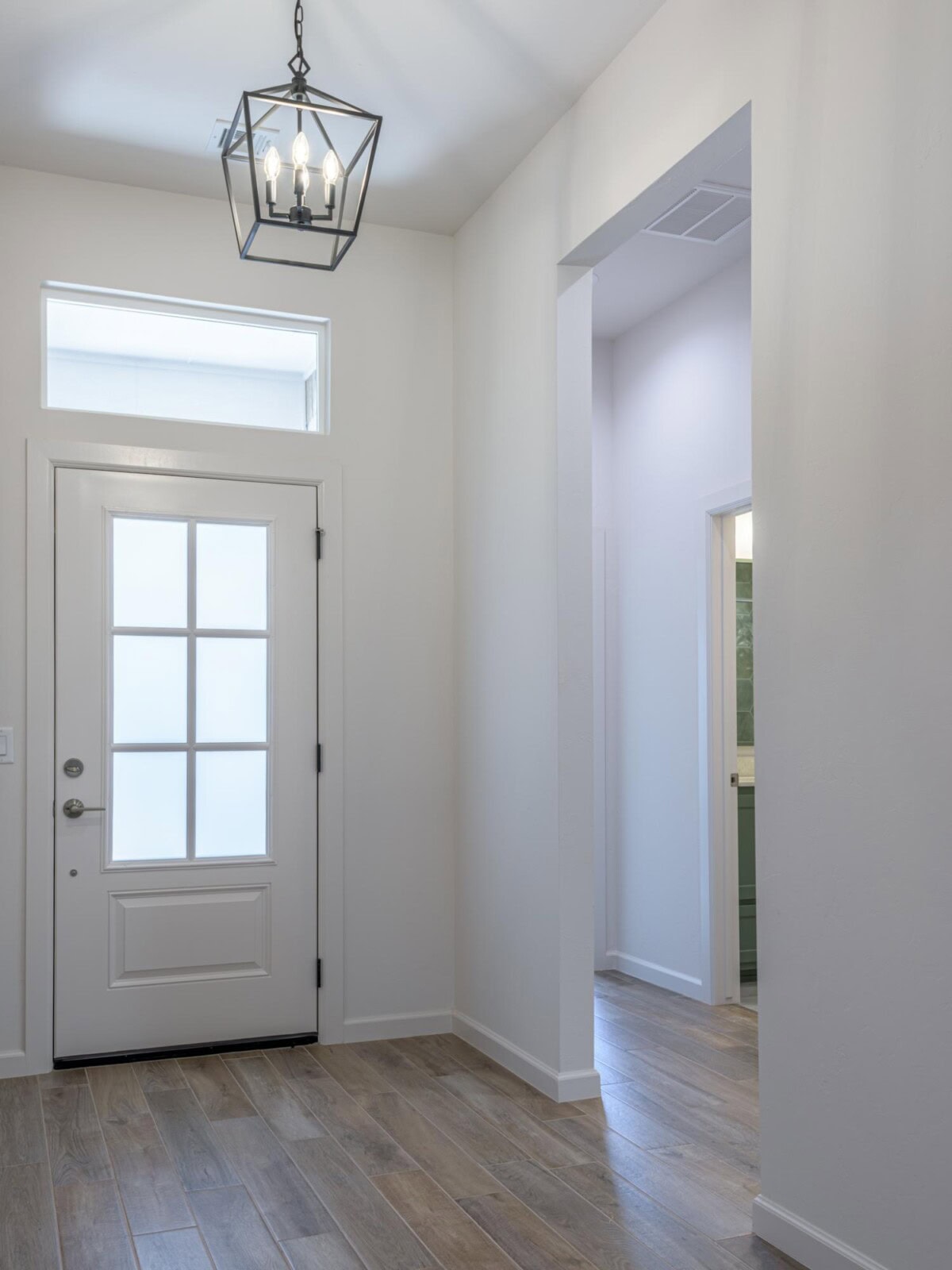 A white door and a light fixture in a hallway