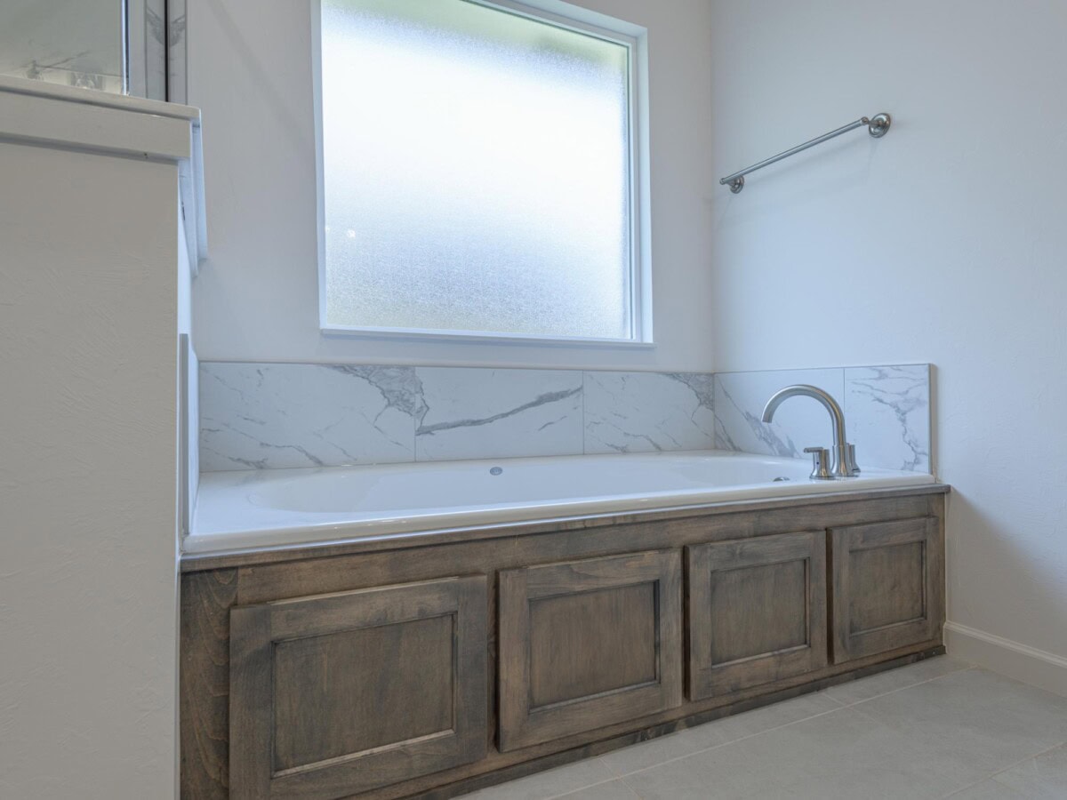 A bathroom with a bath tub and a window