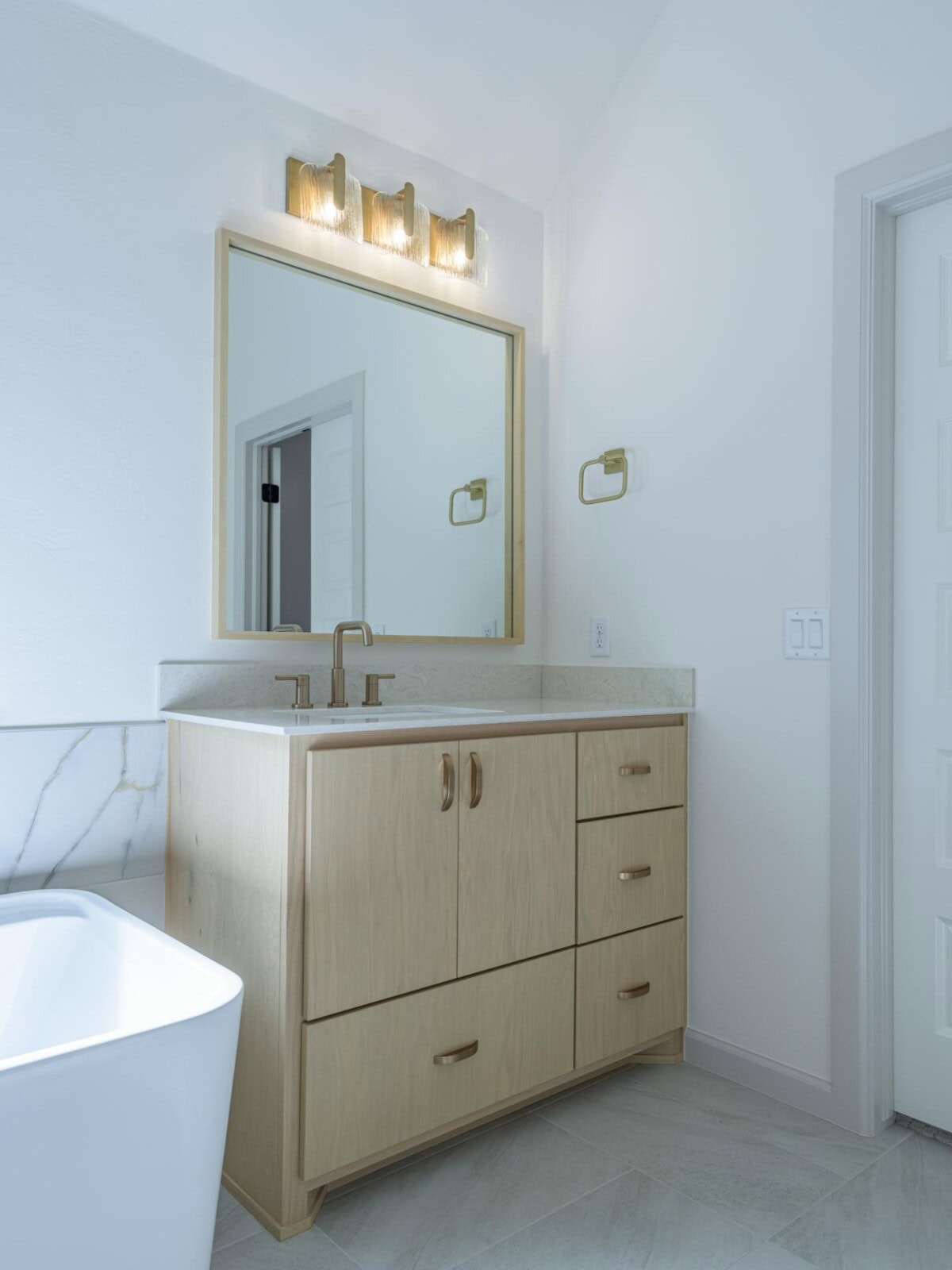 A bathroom with a white tub and a vanity